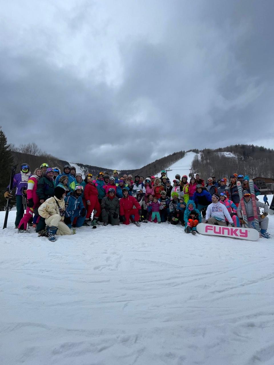 Day-glo crew skiing together at Killington 80s Weekend in matching fluorescent outfits